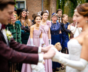 Bruidpaar houdt handen vast, mensen kijken