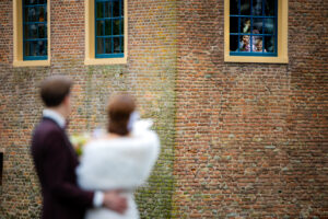 Bruidspaar zwaait naar kinderen in het kasteel