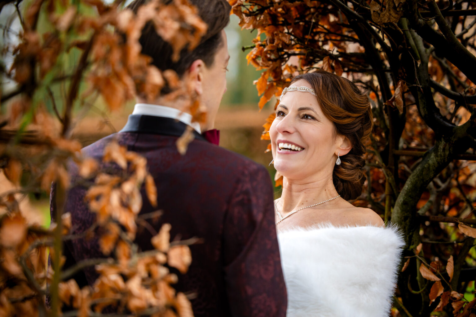 Bruidspaar onder een boog van bladeren